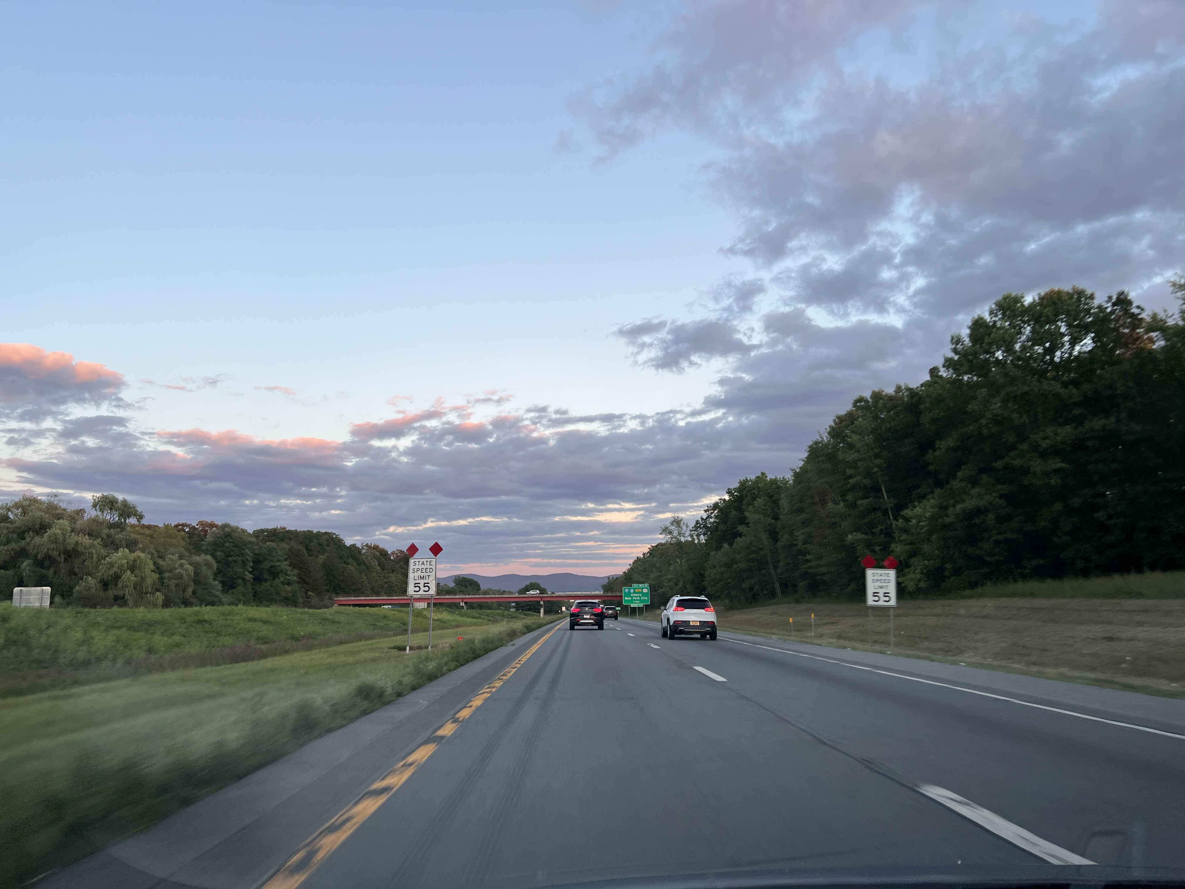 Evening highway drive with a pink-and-blue sky